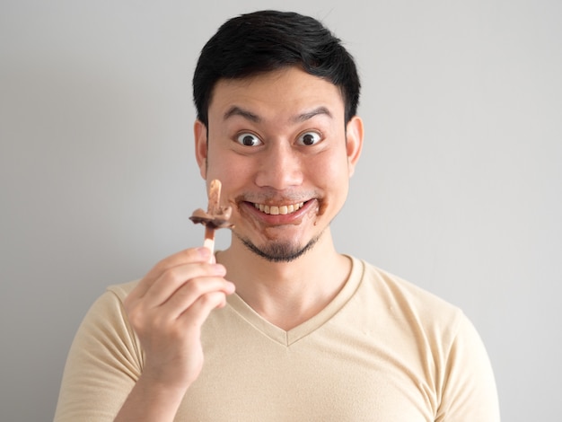 Funny face Asian man eat chocolate vanilla ice pop.