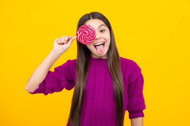 Funny face Excited face Teenage girl with candy lollipop happy child 12 13 14 years old eating big sugar lollipop sweets candy