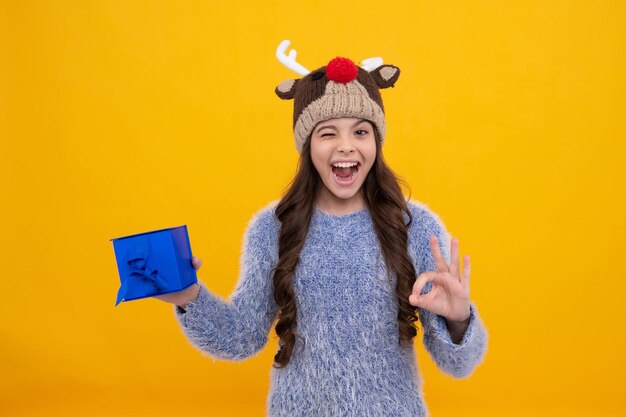 Funny face Funny kid girl in winter wear holding gift boxes celebrating happy New Year or Christmas Winter holiday