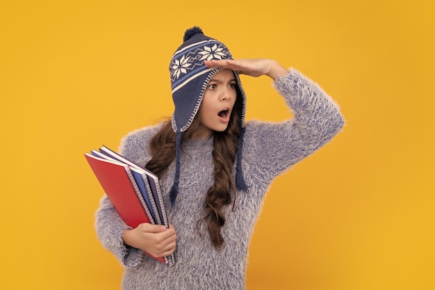 Funny face funny school girl child student with book warn hat isolated yellow background learning