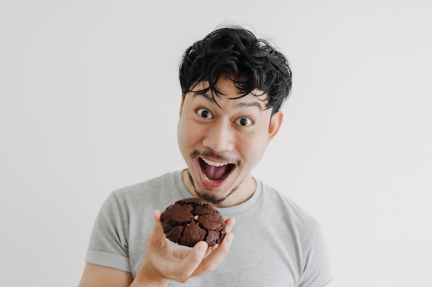 L'uomo faccia buffa mangia il biscotto al cioccolato isolato su sfondo bianco