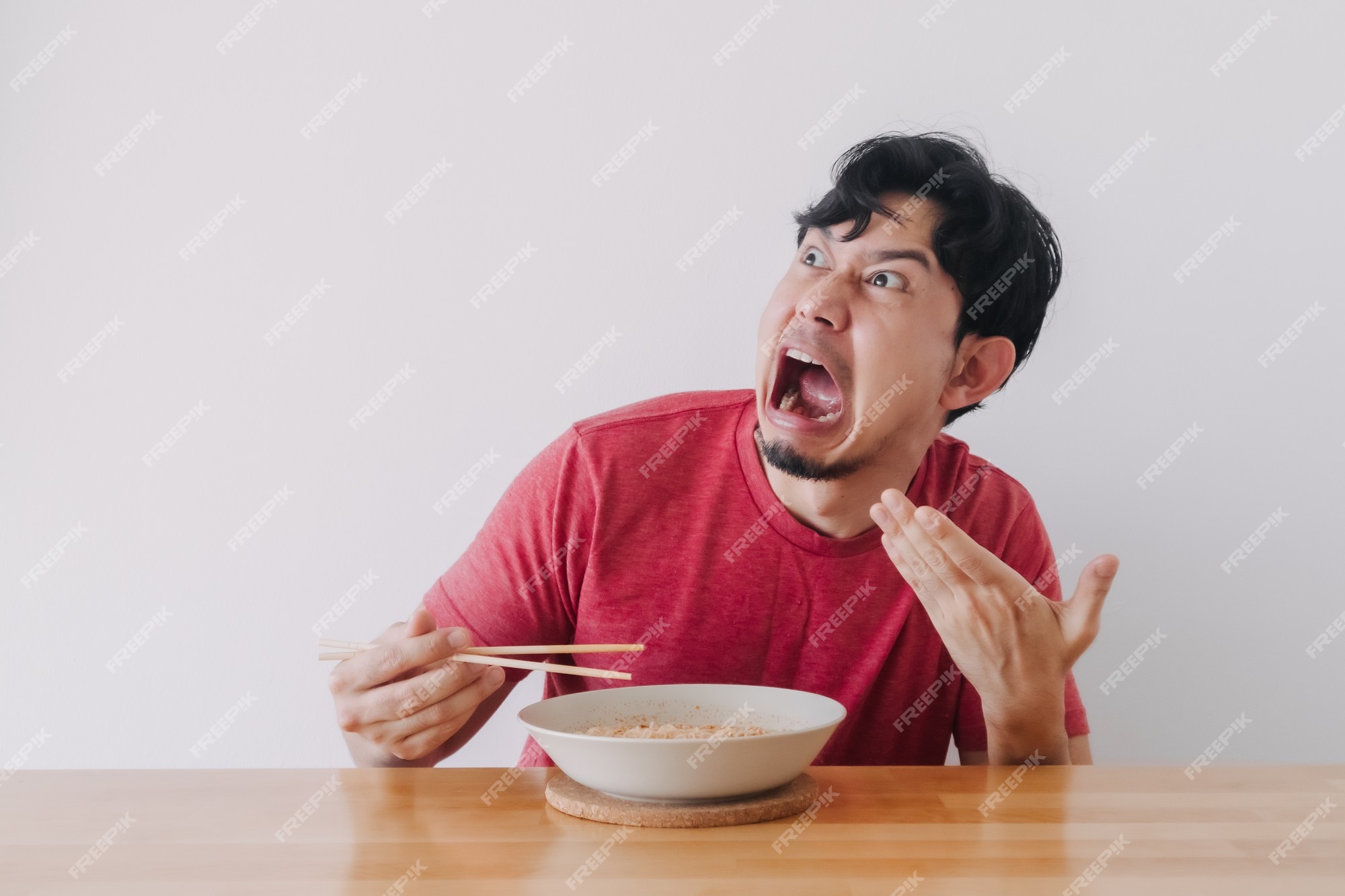 Premium Photo | Funny face of man eat very hot and spicy instant noodle