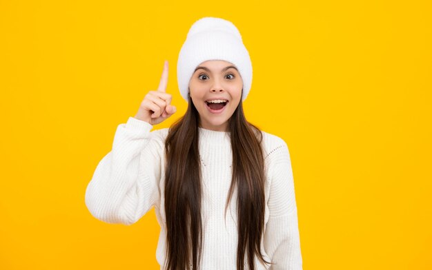 Funny face of young teenager pointing up with finger isolated on yellow background girl has great new idea successful child