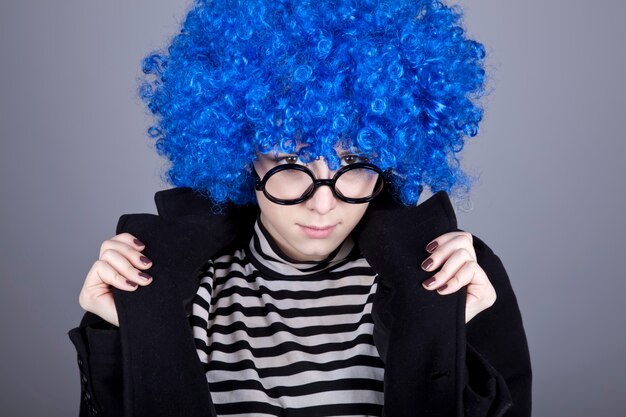 Funny fashion blue-hair girl in glasses and black coat. 