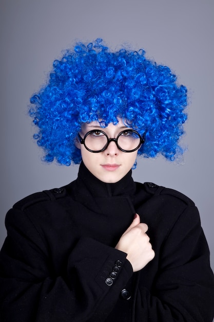 Funny fashion blue-hair girl in glasses and black coat. 