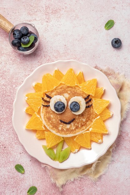 Funny flower pancake with berries for kids