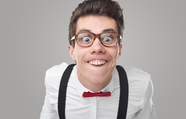 Funny geek in glasses making face in studio