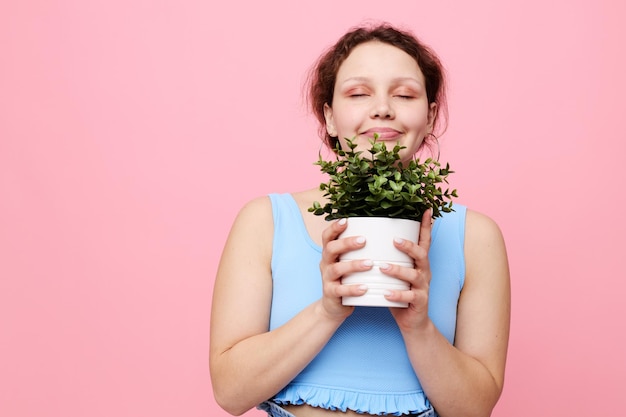 Funny girl in a blue Tshirt and shorts a flowerpot isolated backgrounds unaltered