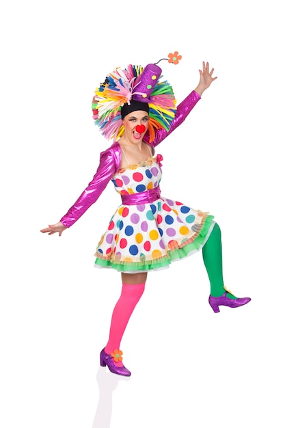 Funny girl clown with a big colorful wig dancing isolated on white background