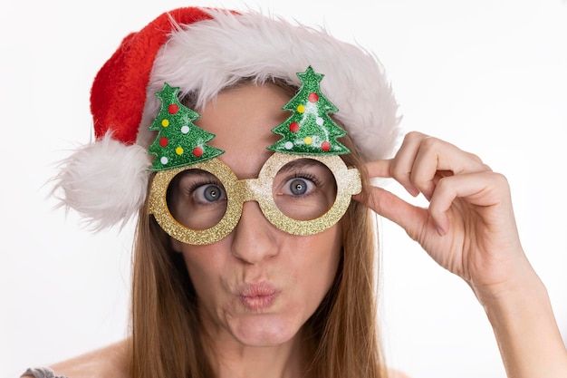 Funny girl in glasses with christmas trees pretty woman in santa claus hat emotions of surprise the