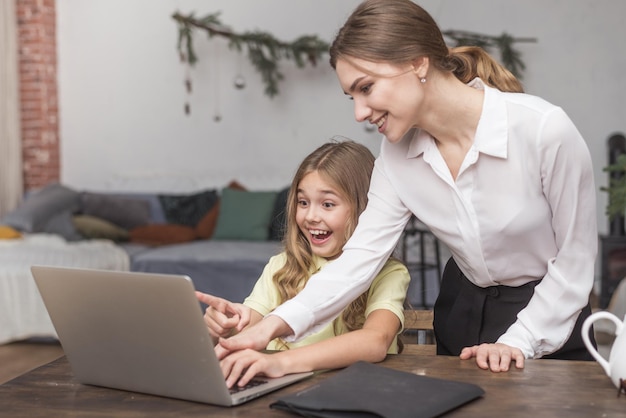 Photo funny girl laugh with mother and computer at home