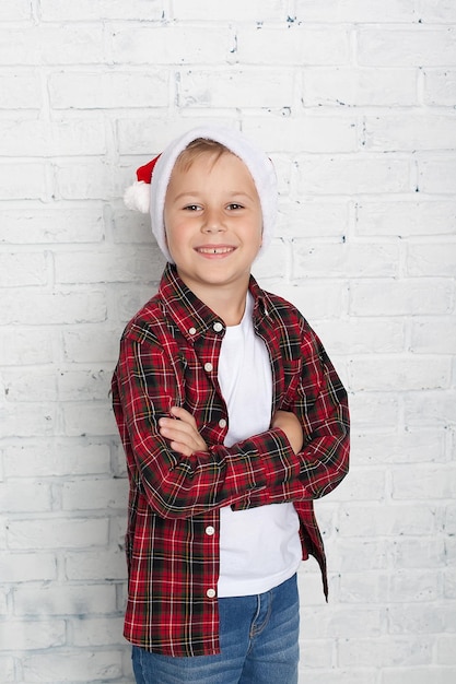 Funny girl in a santa claus hat shows class with her thumb children's emotions portrait of a child on a white background