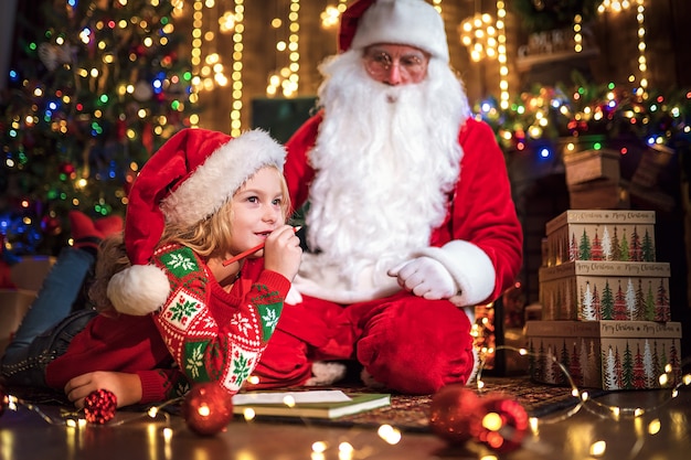 Funny girl in Santa hat writes letter to Santa