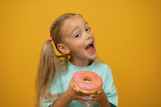 Funny girl with donuts on a yellow background