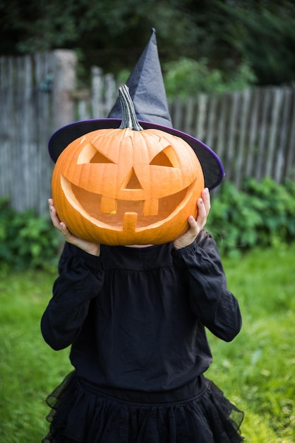 庭でハロウィーンのカボチャと面白い女の子