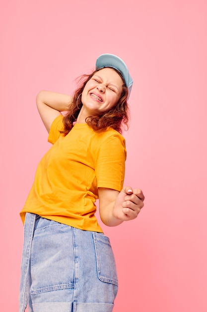 Funny girl in a yellow tshirt and blue cap posing emotions Lifestyle unaltered