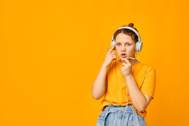 Funny girl yellow tshirt headphones entertainment music fun isolated backgrounds unaltered