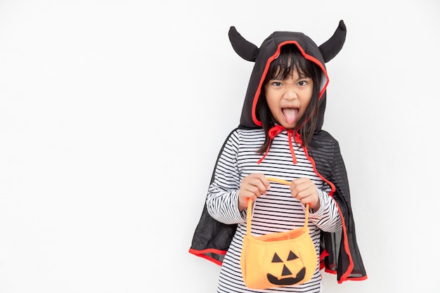 Funny Halloween Kid Concept, little cute girl with costume Halloween ghost scary he holding orange pumpkin ghost on hand, on white background