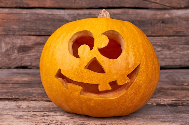 Funny Halloween pumpkin on wooden background.