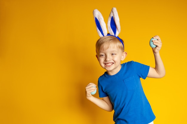 Funny happy boy on a yellow background, easter theme