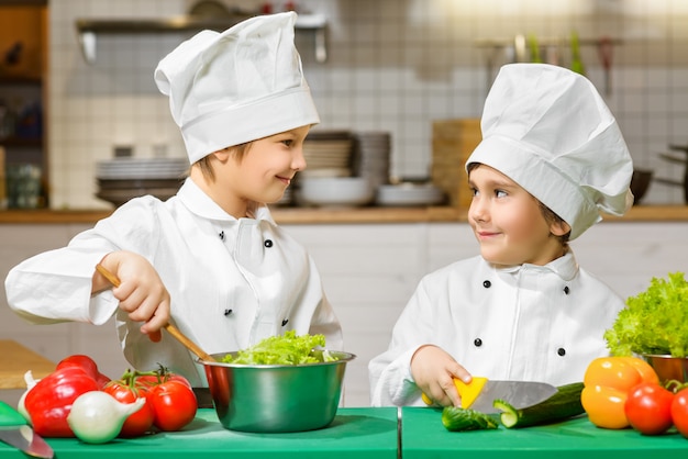 Funny happy boys cooking at restaurant kitchen