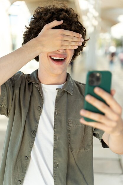 Funny hipster guy clicking selfie images smiling at front smartphone camera