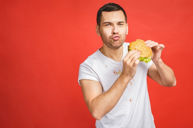 Uomo barbuto affamato divertente che mangia cibo spazzatura