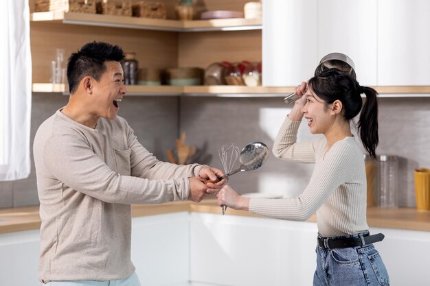 Funny japanese couple having good time while cooking together