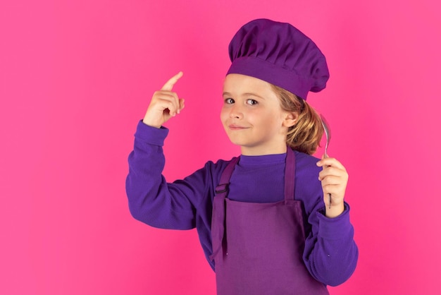 Funny kid chef cook with spoon Child chef cook Child wearing cooker uniform and chef hat preparing food studio portrait