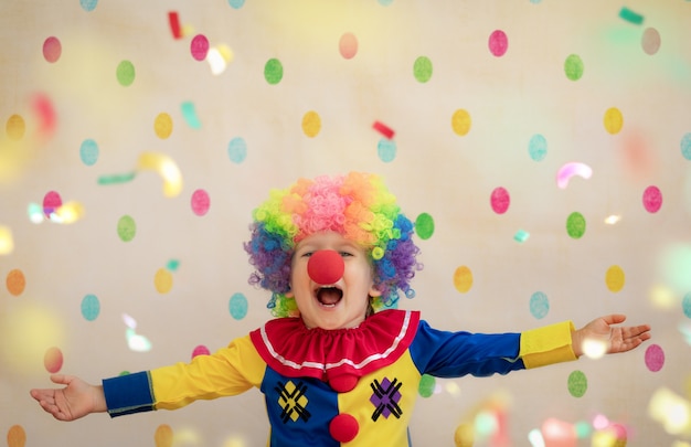 Funny kid clown against polka dot wall.