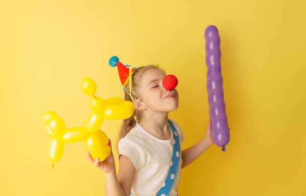Funny kid clown against yellow background Birthday and 1 April Fool's day concept