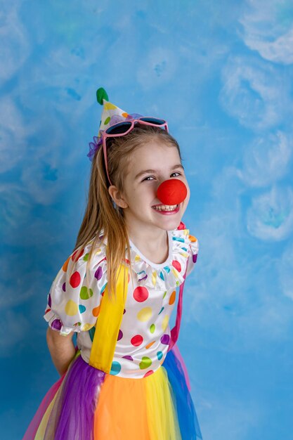 Funny kid clown playing against a bright wall 1 April Fools day concept birthday concept