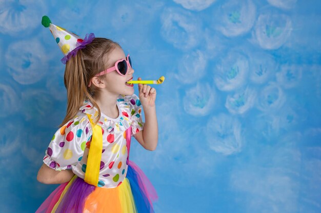 Photo funny kid clown playing against a bright wall 1 april fools day concept birthday concept