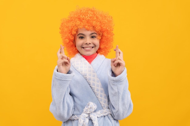 Funny kid in curly clown wig fancy child wear home bathrobe