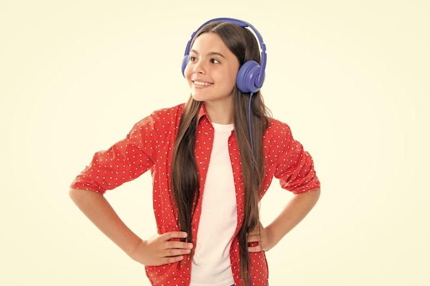 Funny kid girl 12 13 14 years old listen music with headphones Teenage girl with headphones listening songs on headset earphone Portrait of happy smiling teenage child girl