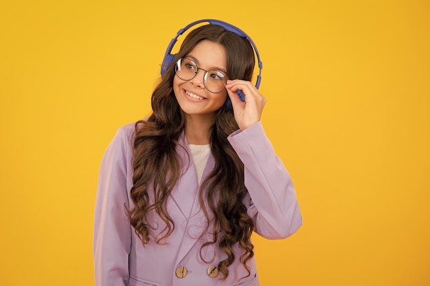 Funny kid girl 12 13 14 years old listen music with headphones teenage girl with headphones listening songs on headset earphone
