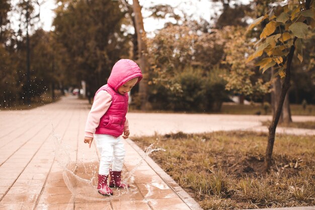 Фото Забавный ребенок девочка держит зонтик в парке