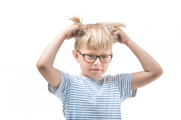 分離した白い背景にポーズをとって面白い子供。彼の頭と髪を保持している小さな男の子の肖像画を閉じます。愛らしい子供思考。