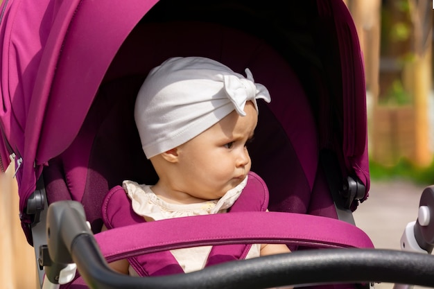 Funny kid walking in a stroller is dissatisfied with something