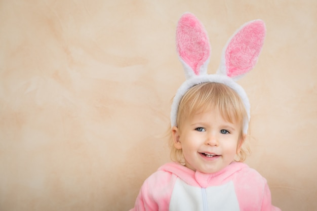 Funny kid wearing Easter bunny. Child having fun at home