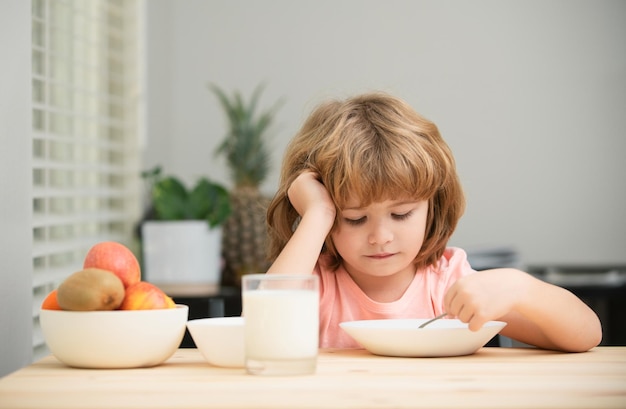 Funny kid with plate of soup child dinner