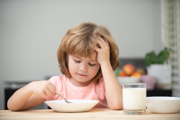 スープの子供の夕食のプレートを持つ面白い子供