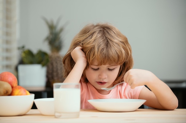 Funny kid with plate of soup child dinner