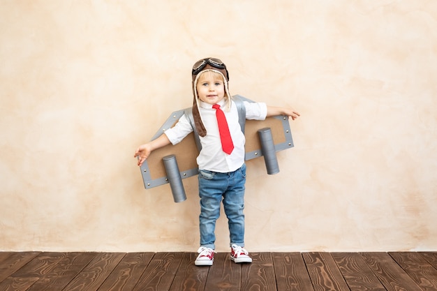 Funny kid with toy cardboard jet pack