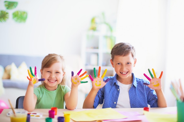 Funny kids show their palms the painted paint. 