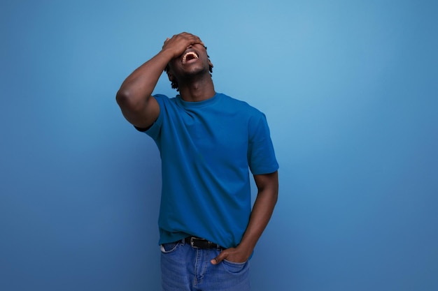 Funny laughing american young guy in a tshirt on a blue background