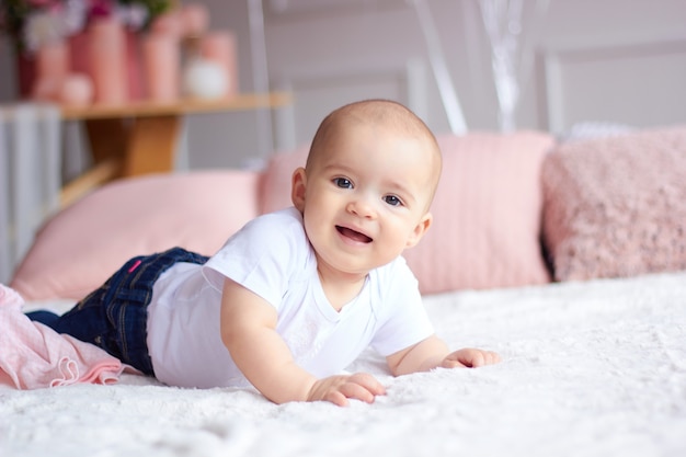 Funny little baby girl in pink bright modern interior