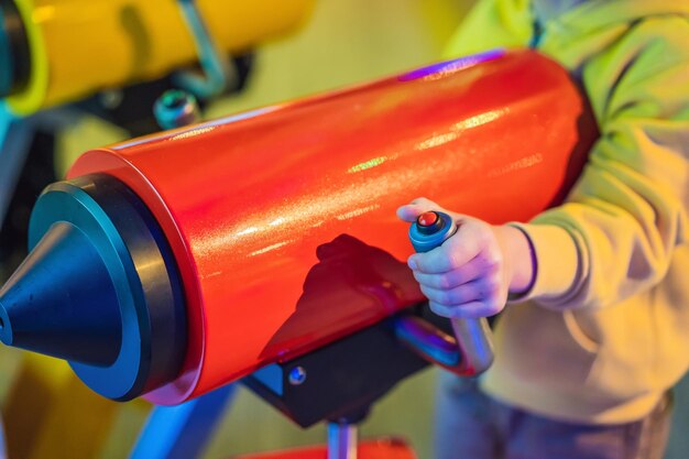 Funny little boy playing with a toy rifle and about to shoot a dart