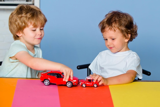 楽しいとおもちゃの車で遊ぶ面白い小さな子供は、就学前のかわいいchで幸せなかわいい賢い男の子の生徒...