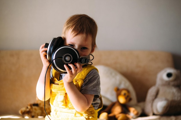 Foto bambino divertente che si diverte con le cuffie a casa ritratto